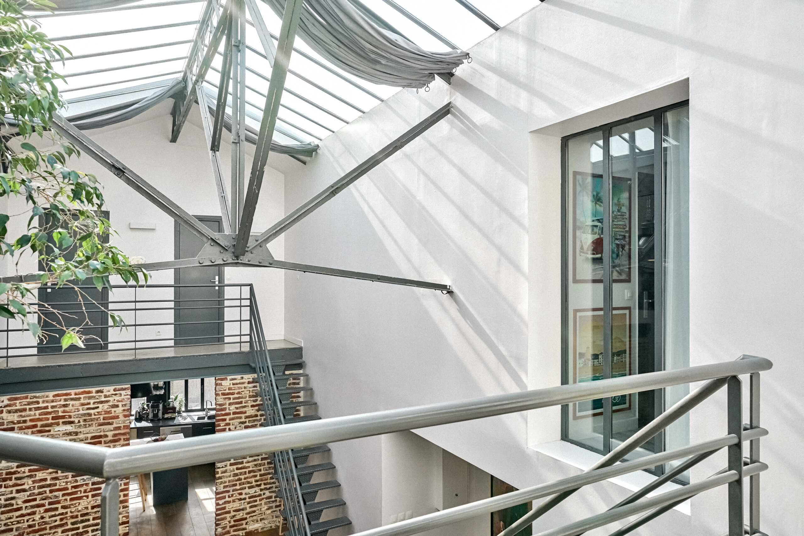 Passerelle mezzanine avec garde-corps tubulaire, verrière cathédrale et perspectives verticales sur colonnes briques pour prises de vue architecturales et films d'art